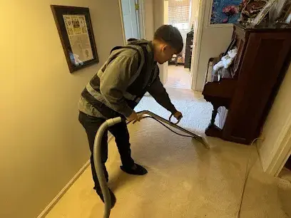 Extraction wand pulling water from carpet in an Everett hallway
