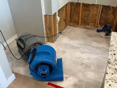 Air mover drying a kitchen wall base after water damage in Everett